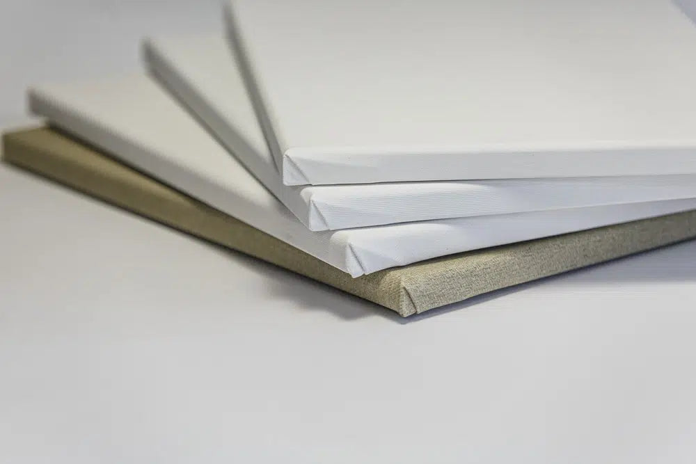 Ein Stapel bespannter Leinwände liegt bereit zum Malen.